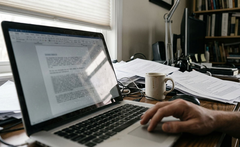 Home office writing setup with laptop displaying a plaintext draft on Monarch mind control evidence